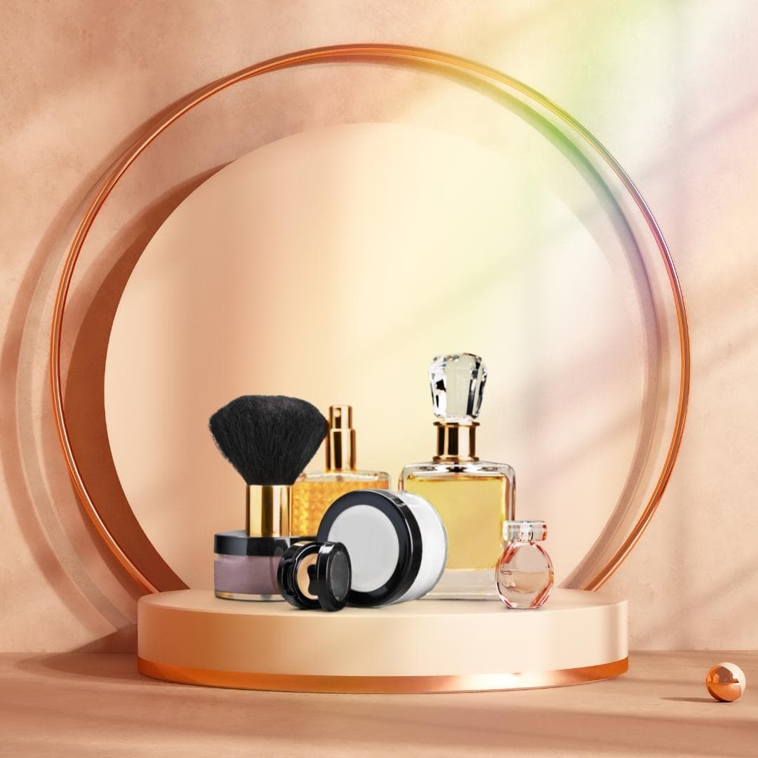 Perfume, powder compact, and a makeup brush styled inside a rose-gold ring display